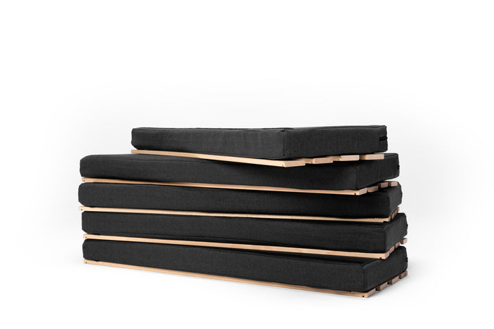 Die fünfteilige travel tiger Campingmatratze mit Lattenrost liegt übereinander gestapelt vor einem weißen Hintergrund.