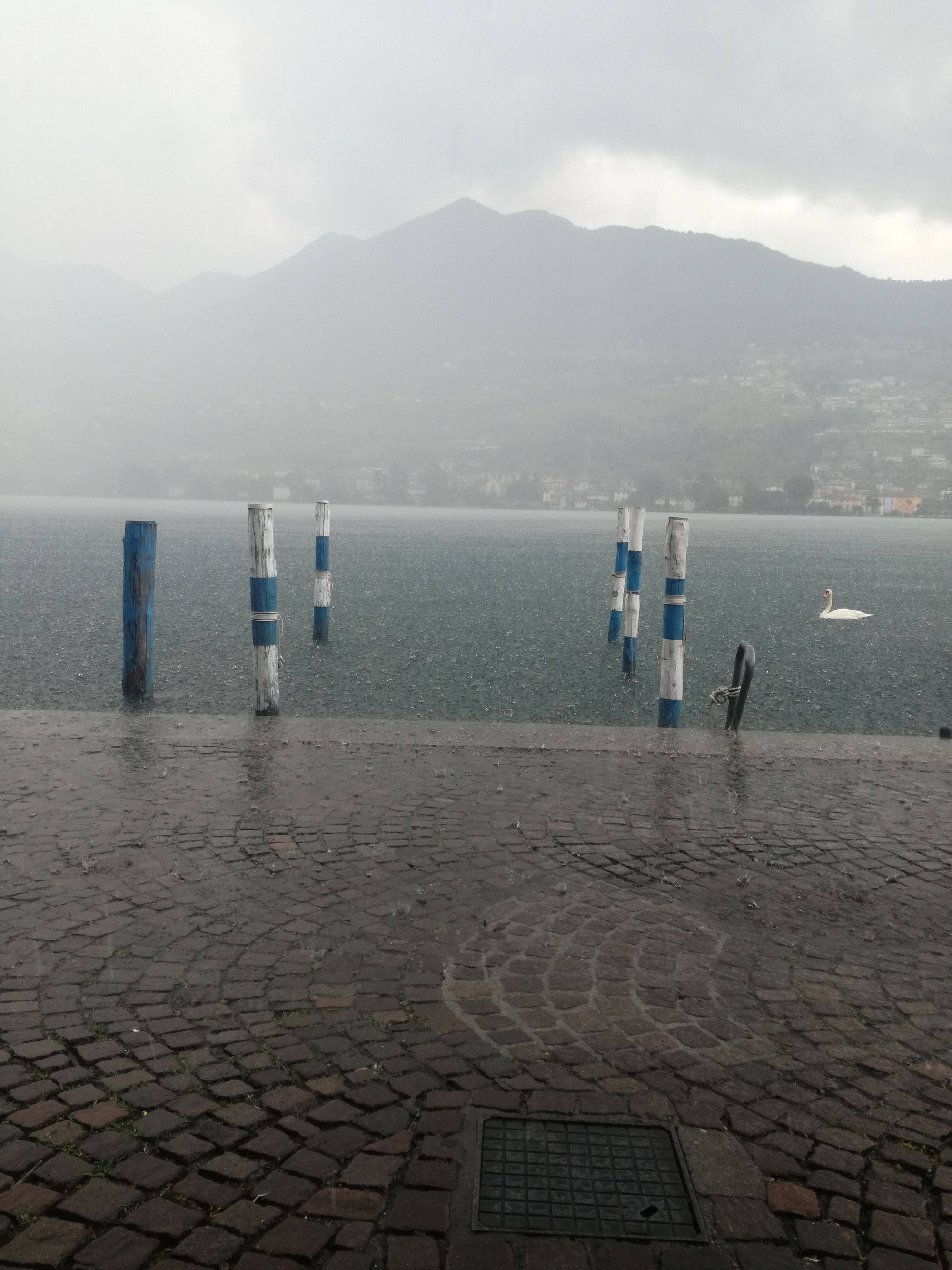 Regenschauer über dem See und der Uferpromenade. 