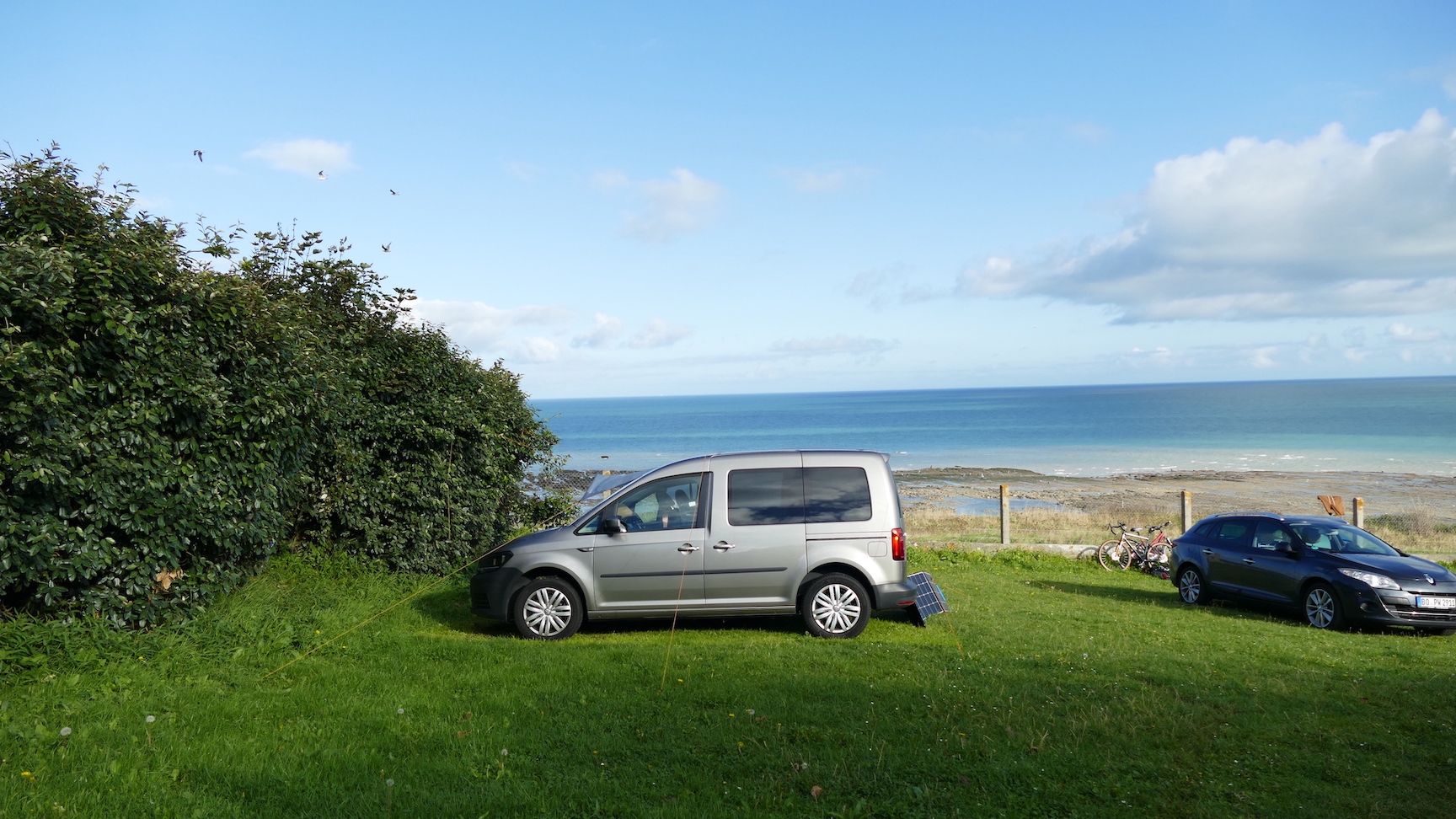 VW Caddy steht auf einem Campingplatz mit Meerblick.