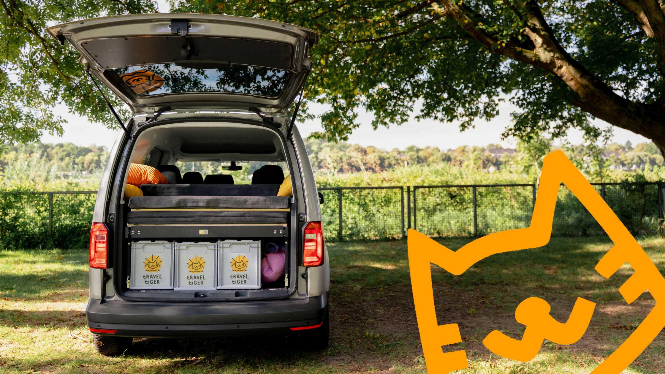 VW Caddy mit Campingmodulen auf einem Campingplatz.