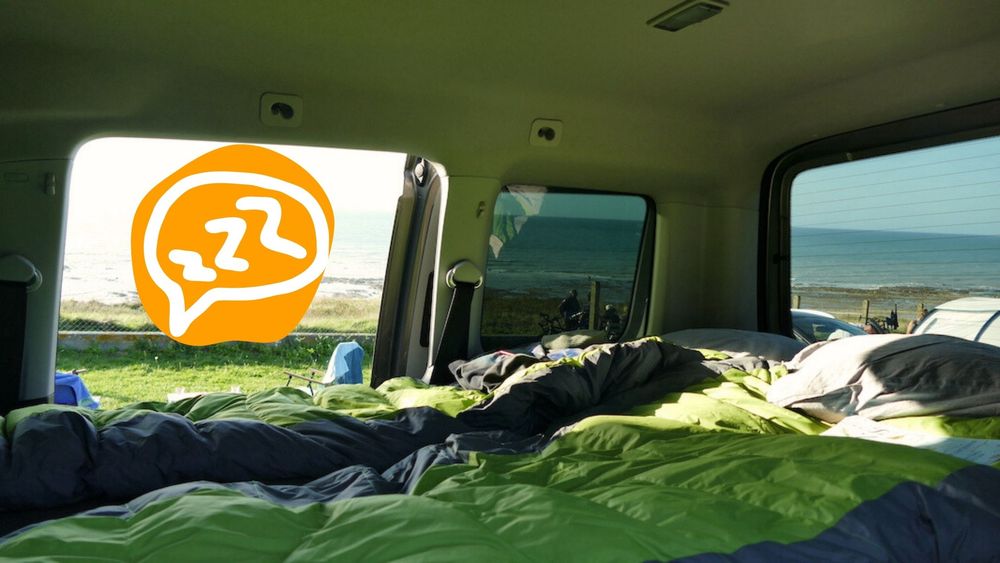 Foto von aufgebautem Campingbett mit Schlafsäcken in kleinem Auto.