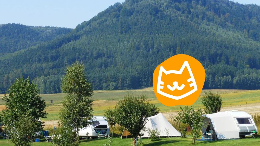 Kleiner Campingplatz zwischen grünen Bergen.