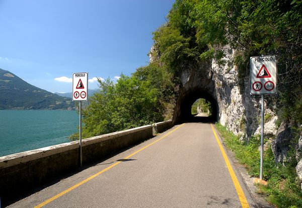 Eine asphaltierte Straße, die direkt am Iseosee entlang führt.